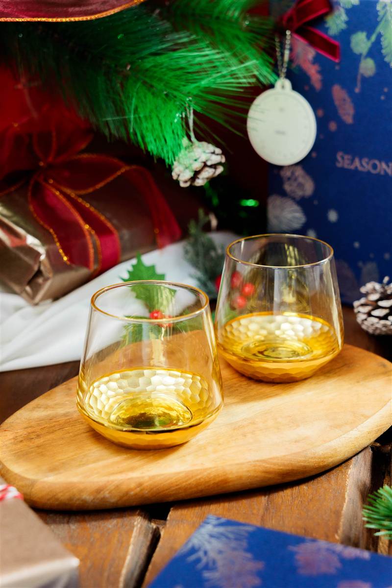 Gold-dipped tumblers on a wooden board with Christmas props, Red Ribbon