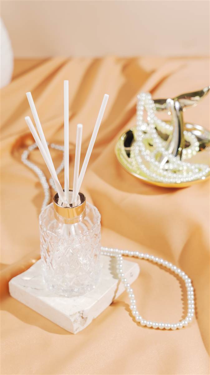 Crystal reed diffuser on a white block with pearls, Red Ribbon